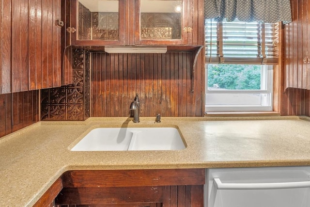 259 Main St, Blackstone, MA 01504 - kitchen featuring a sink, plenty of natural light, glass insert cabinets, wood walls, and light stone counters