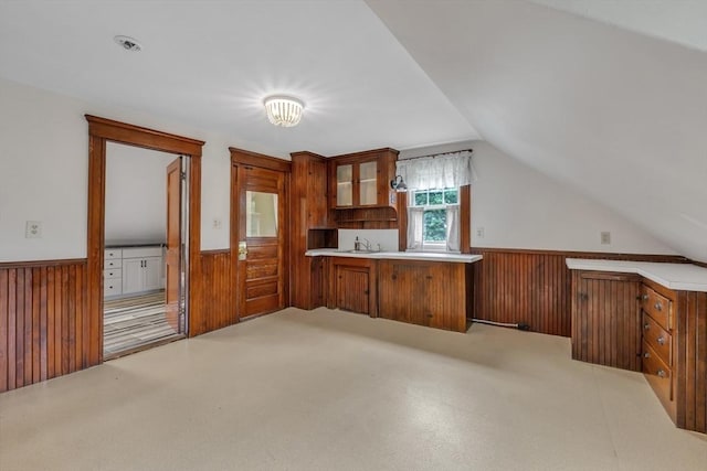 259 Main St, Blackstone, MA 01504 - kitchen featuring a wainscoted wall, a sink, wooden walls, brown cabinetry, and vaulted ceiling