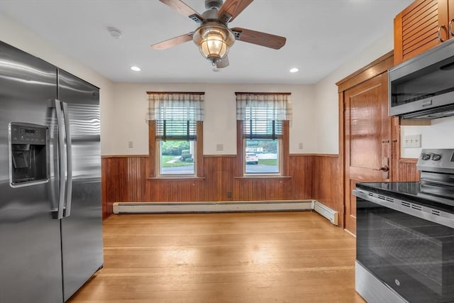 259 Main St, Blackstone, MA 01504 - kitchen with appliances with stainless steel finishes, a wainscoted wall, light wood-style floors, brown cabinets, and wood walls