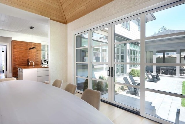 entryway with light hardwood / wood-style flooring, wood ceiling, vaulted ceiling, and sink