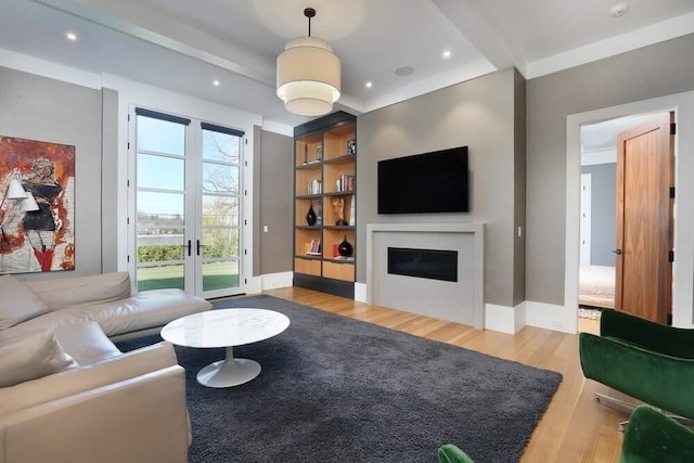 living room featuring french doors, light hardwood / wood-style flooring, and built in features