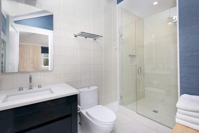 bathroom featuring vanity, decorative backsplash, toilet, tile walls, and a shower with shower door