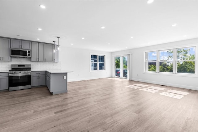 47 Parker St Unit 3, Quincy, MA 02169 - kitchen featuring appliances with stainless steel finishes, gray cabinetry, a peninsula, light countertops, and open floor plan