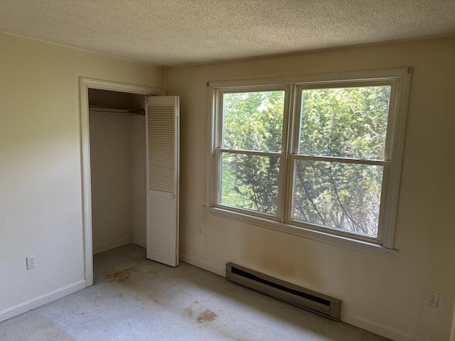 11 Glenwood St, Whitman, MA 02382 - unfurnished bedroom featuring a baseboard radiator, multiple windows, light carpet, a textured ceiling, and a closet