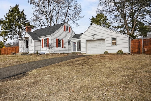 view of front of home featuring fence, driveway, an attached garage, a chimney, and entry steps