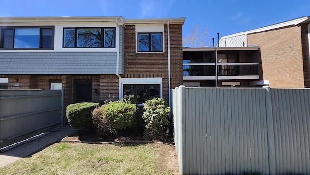 view of front of house featuring brick siding and fence