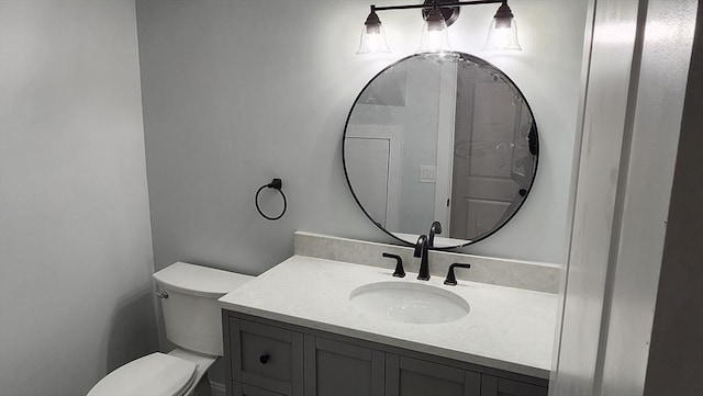 half bathroom featuring vanity and toilet