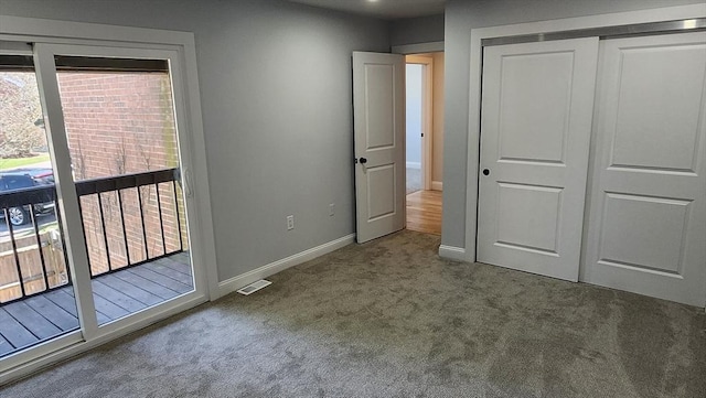 unfurnished bedroom featuring carpet, visible vents, a closet, baseboards, and access to outside