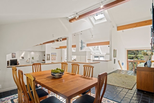 dining area featuring a skylight, beamed ceiling, high vaulted ceiling, and rail lighting