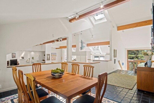 living room with vaulted ceiling with beams, hardwood / wood-style floors, and rail lighting