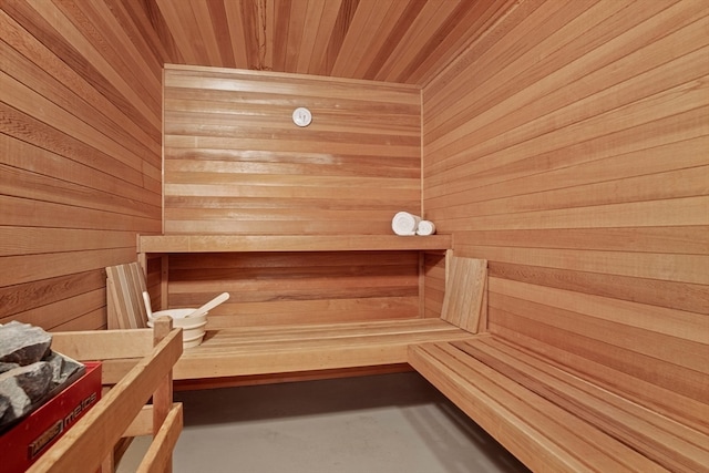 view of sauna / steam room with wooden ceiling and wooden walls