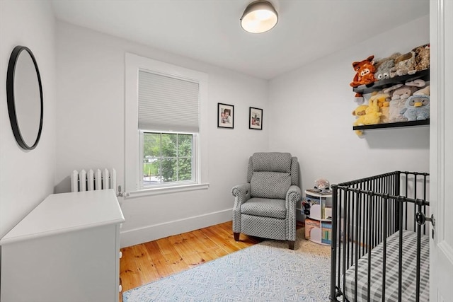 115 Elm St, Andover, MA 01810 - bedroom with radiator heating unit, wood finished floors, and a crib
