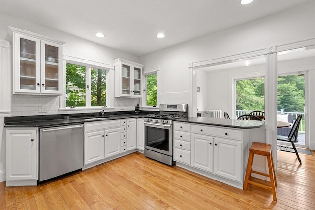 115 Elm St, Andover, MA 01810 - kitchen featuring appliances with stainless steel finishes, healthy amount of natural light, a peninsula, white cabinets, and recessed lighting