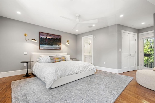 bedroom featuring baseboards, wood finished floors, recessed lighting, and connected bathroom