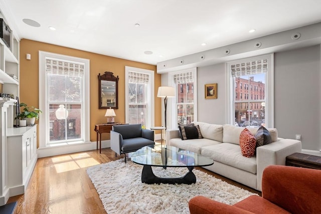 living area with light wood finished floors, plenty of natural light, and recessed lighting