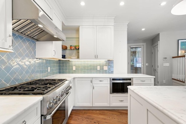 kitchen with stainless steel appliances, under cabinet range hood, light wood finished floors, white cabinets, and recessed lighting