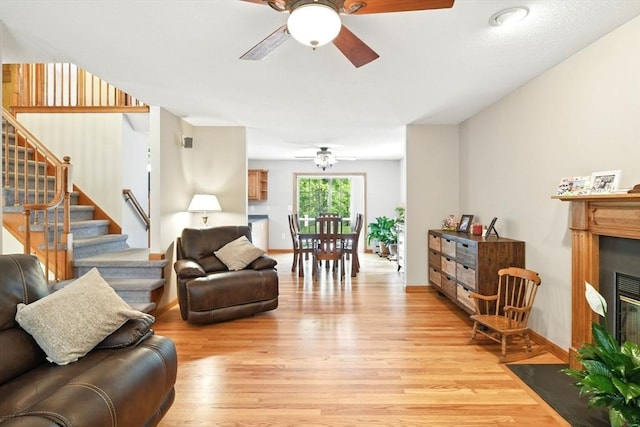 315 Woodland Way, Russell, MA 01071 - living room with a ceiling fan, a fireplace with flush hearth, light wood finished floors, and stairs