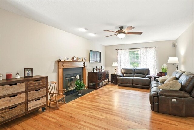 315 Woodland Way, Russell, MA 01071 - living room featuring wood finished floors, a fireplace with flush hearth, and a ceiling fan