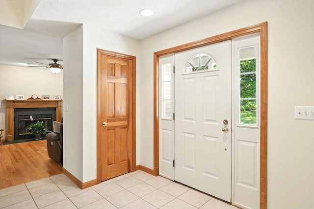 315 Woodland Way, Russell, MA 01071 - entrance foyer with a ceiling fan, light tile patterned floors, a glass covered fireplace, and baseboards