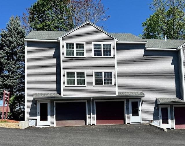 80 Smith St Unit 2A, Lowell, MA 01851 - view of front facade featuring an attached garage, driveway, and roof with shingles