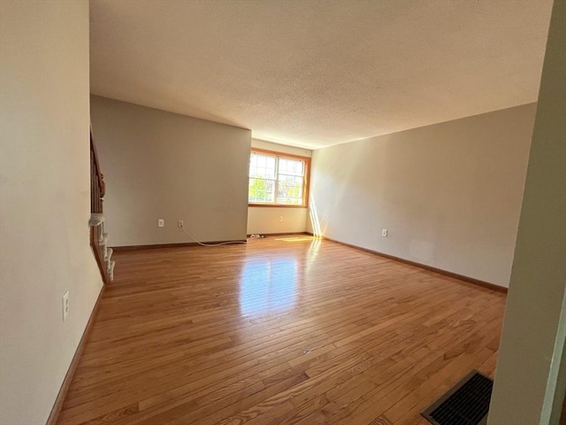 80 Smith St Unit 2A, Lowell, MA 01851 - unfurnished room featuring light wood-style floors, baseboards, and a textured ceiling