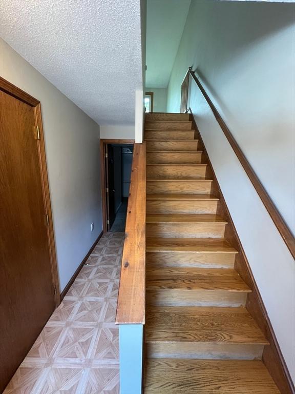 80 Smith St Unit 2A, Lowell, MA 01851 - stairs with a textured ceiling
