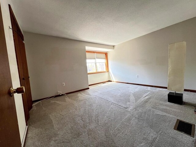 80 Smith St Unit 2A, Lowell, MA 01851 - unfurnished room with carpet flooring, baseboards, and a textured ceiling