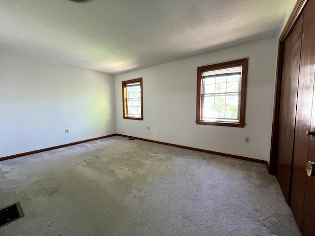 80 Smith St Unit 2A, Lowell, MA 01851 - unfurnished bedroom with light colored carpet, baseboards, and a closet