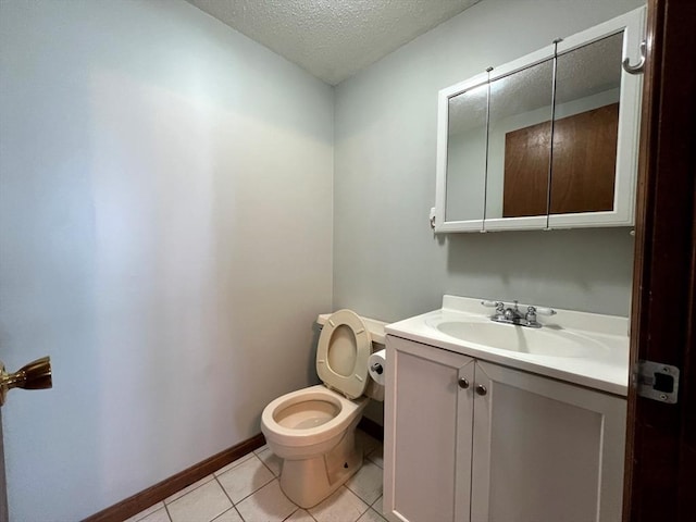 80 Smith St Unit 2A, Lowell, MA 01851 - half bath featuring a textured ceiling, toilet, vanity, tile patterned flooring, and baseboards