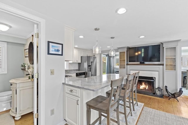 28 Manomet Beach Blvd, Plymouth, MA 02360 - kitchen with stainless steel fridge, light wood-style flooring, a peninsula, light stone countertops, and white cabinetry