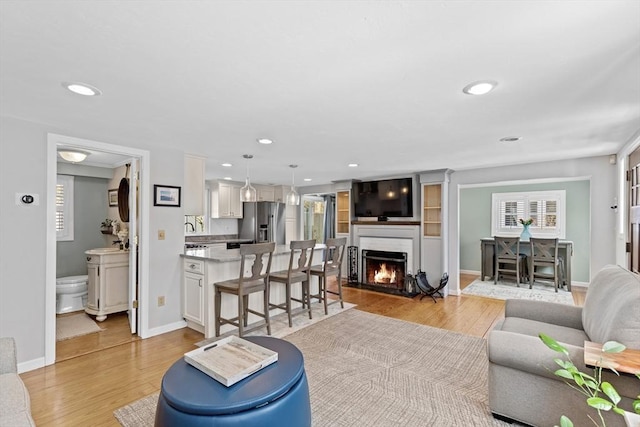 28 Manomet Beach Blvd, Plymouth, MA 02360 - living room featuring light wood-style flooring, a fireplace with flush hearth, recessed lighting, and baseboards