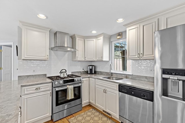 28 Manomet Beach Blvd, Plymouth, MA 02360 - kitchen featuring appliances with stainless steel finishes, wall chimney range hood, a sink, white cabinetry, and recessed lighting