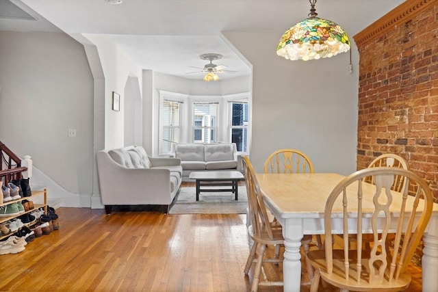 dining space with hardwood / wood-style floors and ceiling fan