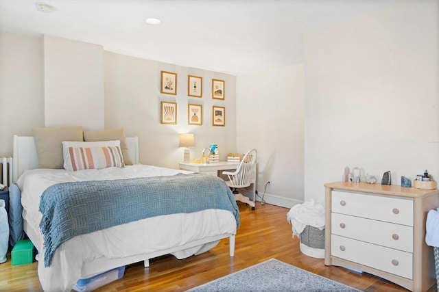 bedroom featuring hardwood / wood-style floors and radiator heating unit