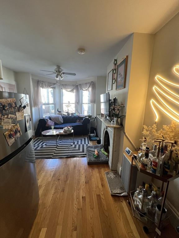 living room featuring hardwood / wood-style floors and ceiling fan