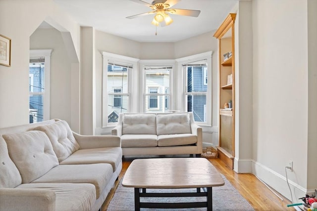 living room with light wood-type flooring and ceiling fan