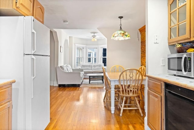 kitchen featuring ceiling fan, hanging light fixtures, light hardwood / wood-style floors, light brown cabinetry, and white fridge