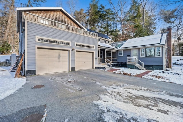 view of property featuring a balcony, a garage, and solar panels