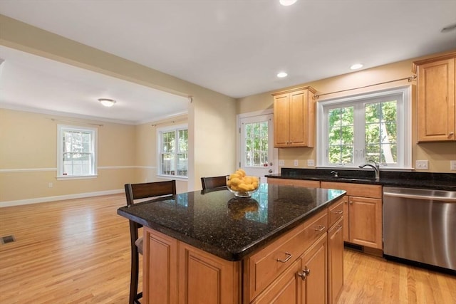 kitchen featuring dark stone counters, dishwasher, sink, and a kitchen island