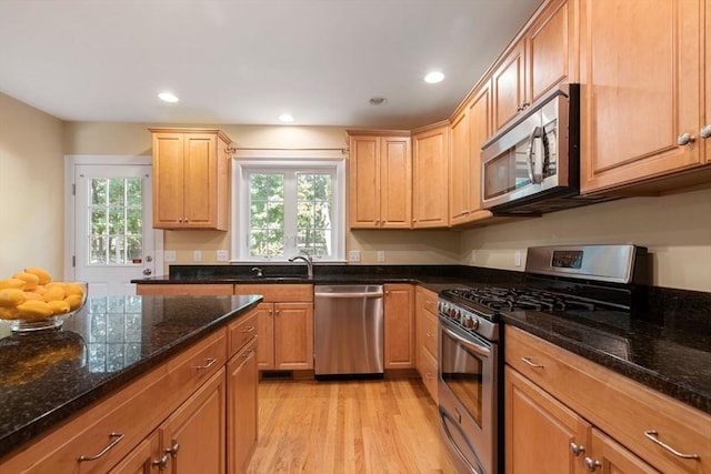 kitchen featuring stainless steel appliances, sink, light hardwood / wood-style floors, and light brown cabinets