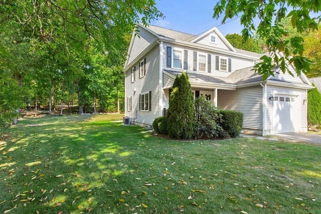 view of side of property featuring a garage, a lawn, and central air condition unit