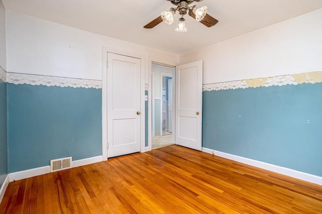 unfurnished room featuring ceiling fan, baseboards, and wood finished floors