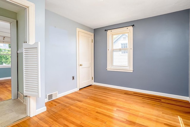 empty room featuring baseboards and light wood-style flooring