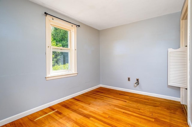 spare room featuring baseboards and light wood-style floors