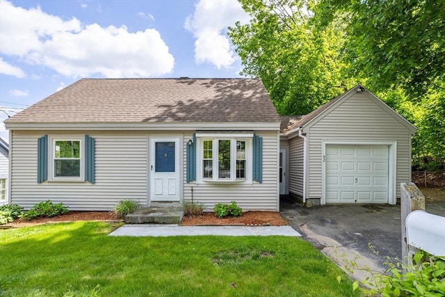 new england style home with driveway, a front lawn, roof with shingles, and a garage