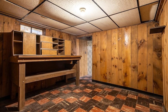 below grade area with wood walls and a paneled ceiling