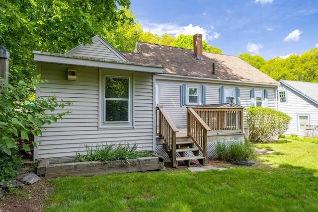 back of house with a lawn, a chimney, and a deck