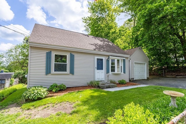 cape cod house featuring a shingled roof, driveway, and a garage