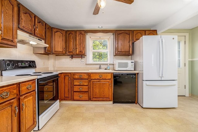 kitchen with white appliances, under cabinet range hood, light countertops, and brown cabinets