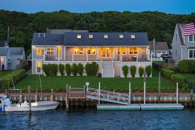 rear view of property with a yard and a water view